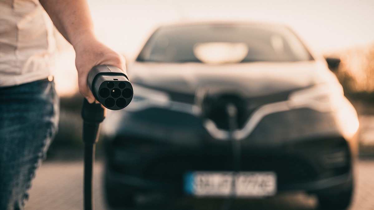 Ein Mann lädt das Elektroauto Zoe des Autobauers Renault